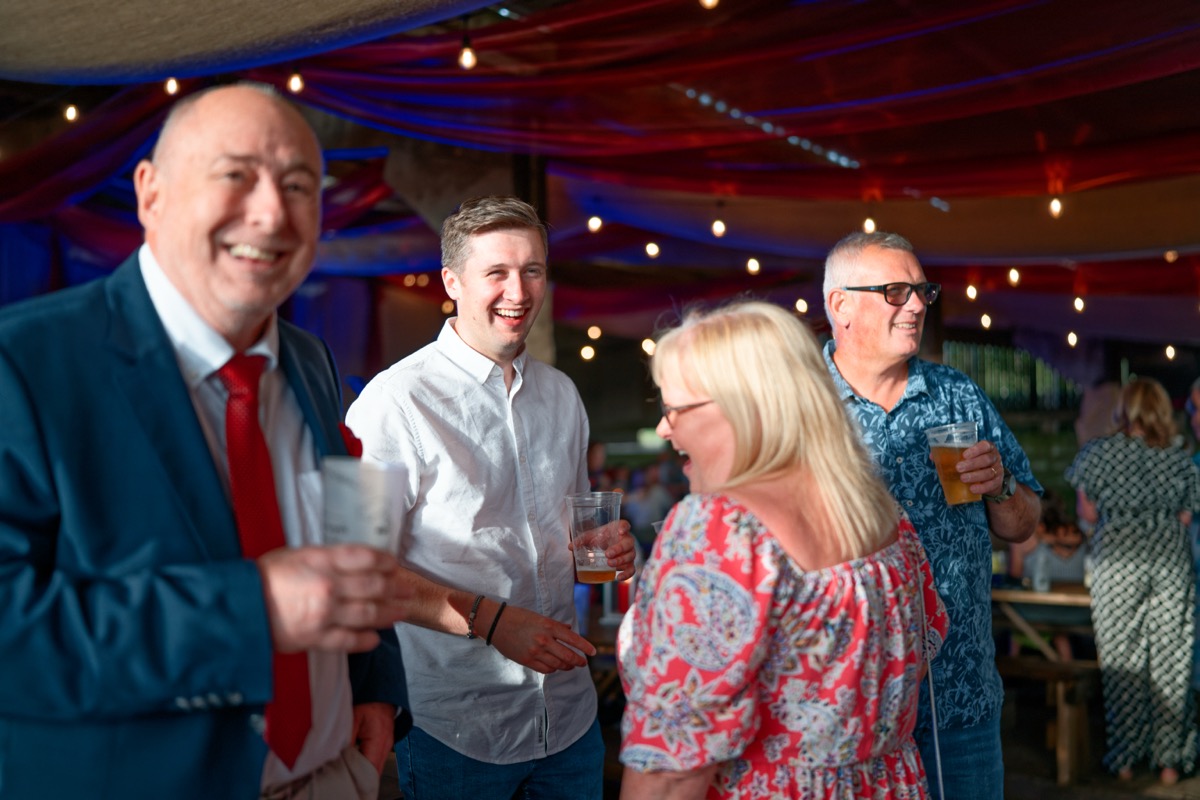 Guests enjoying drinks and conversation at an outdoor evening event
