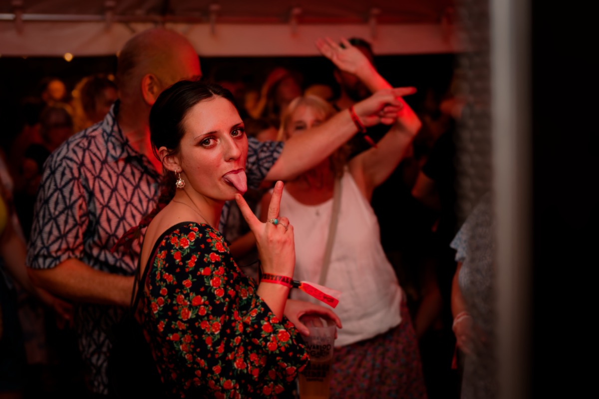 Festival-goer dancing in a crowded room lit by red light