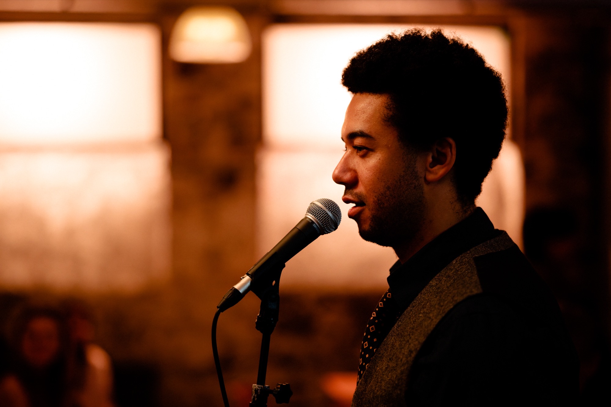 Singer performing at a warm-lit venue in Cardiff