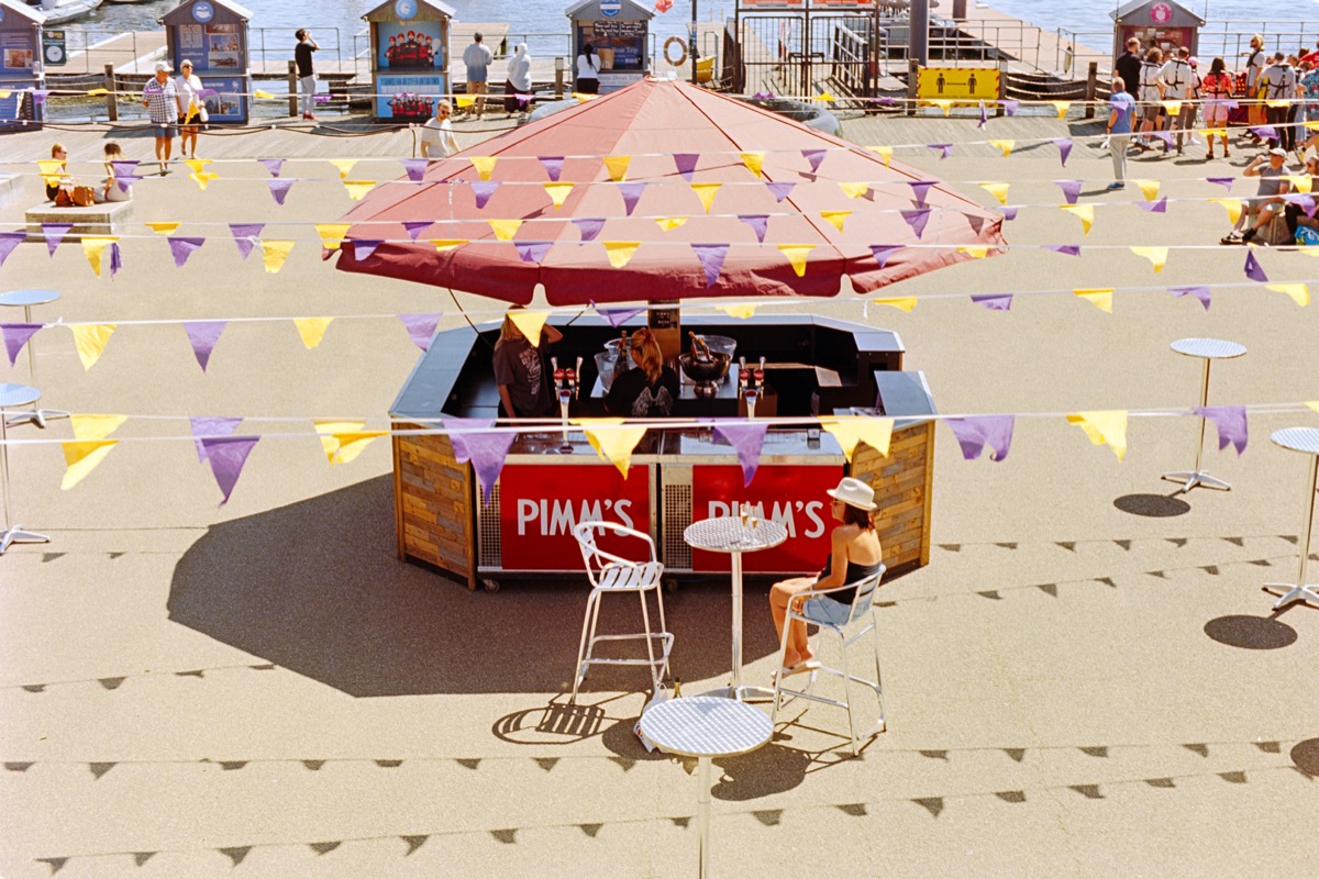 Pimm's bar with bunting on a seaside promenade, shot from above