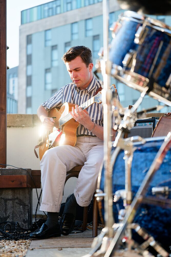 A guitarist with guitar glinting in the sun